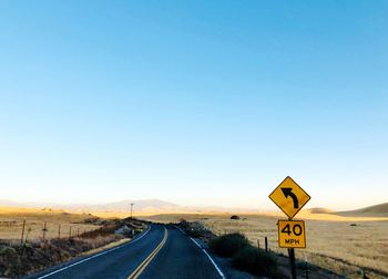 Road sign against blue sky