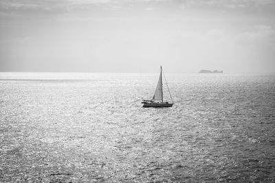 Sailboat sailing on sea against sky