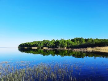 Scenic view of lake against clear blue sky