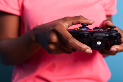 Midsection of man holding remote control