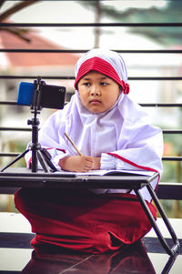 Portrait of girl sitting on table