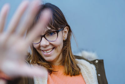 Smiling young woman against wall