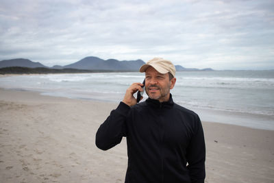 Side view of man photographing at beach