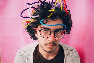 Portrait of man with multi colored strings in hair