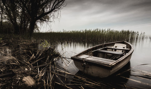 Boat moored in lake against sky