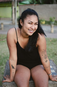 Portrait of a smiling young woman sitting outdoors