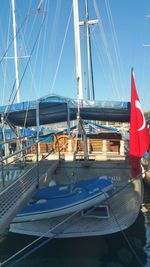 Sailboats moored at harbor against clear blue sky