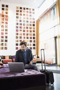 Businessman using laptop in hotel lobby