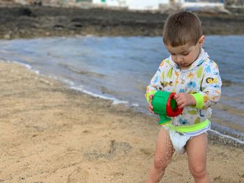Cute boy with toy playing at beach