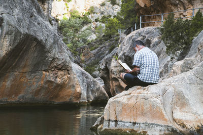 Man reads a book while enjoying the tranquility of the mountain