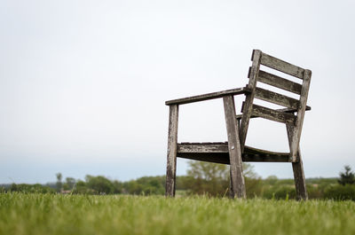 Empty chair on field against clear sky