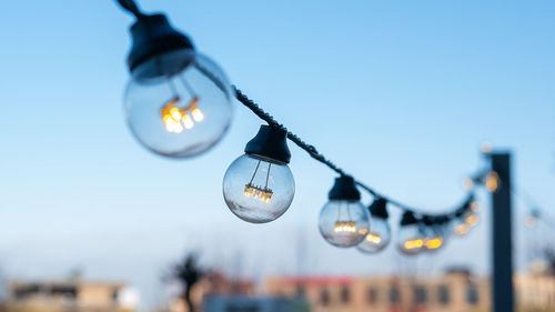 Low angle view of light bulbs against sky