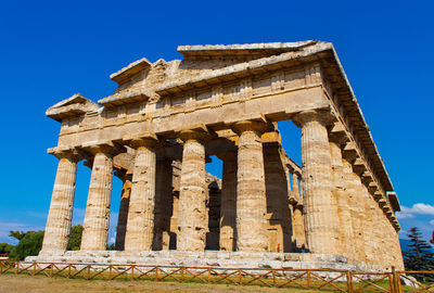 Low angle view of old temple against clear blue sky