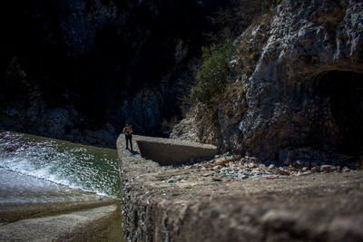 Man standing on rocks against the wall