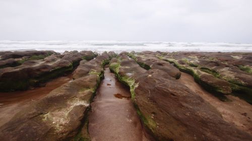 Rocks in sea against sky