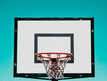 Close-up of basketball hoop against blue background