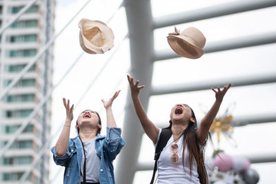 Cheerful females throwing hats