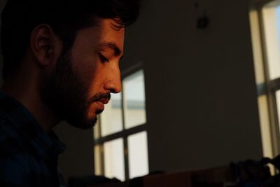 Side view of thoughtful man at home