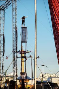 Low angle view of electricity pylon against clear blue sky