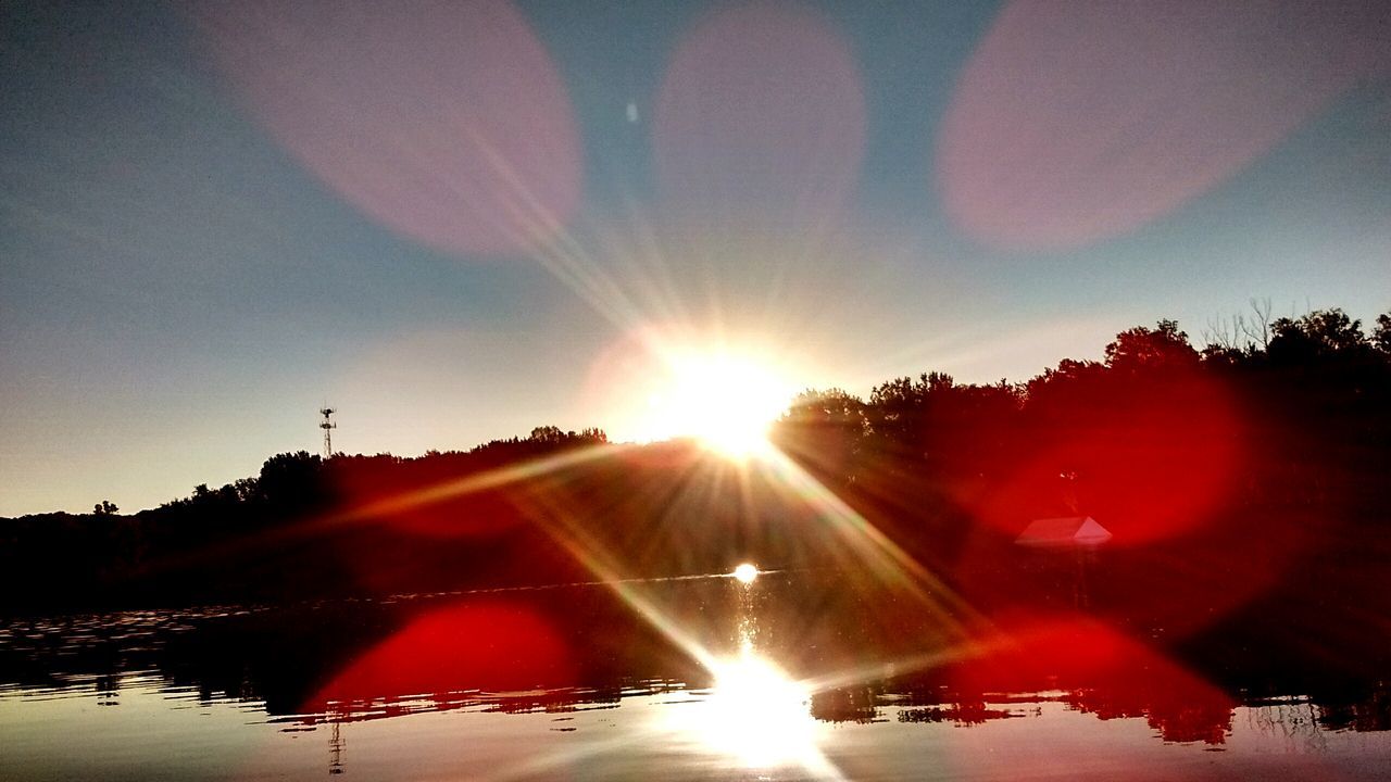 SUN SHINING OVER CALM LAKE