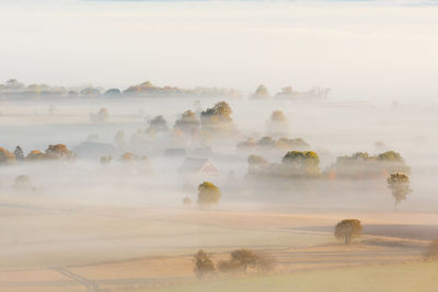 Scenic view of landscape against sky during foggy weather