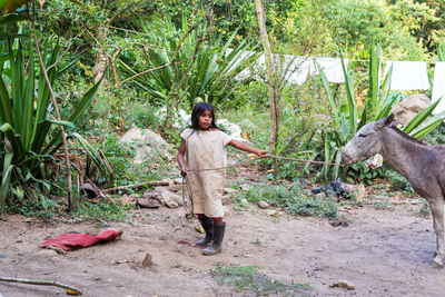 Full length of woman standing on tree trunk