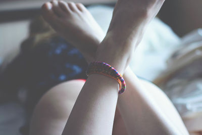 Rear view of woman lying on bed at home