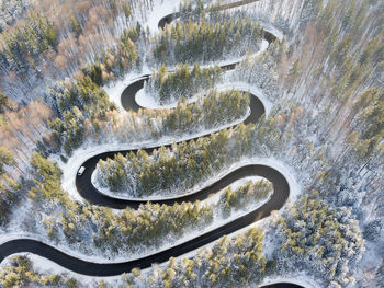 Winding road through the forest, from high mountain pass, winter. aerial view by drone. brasov