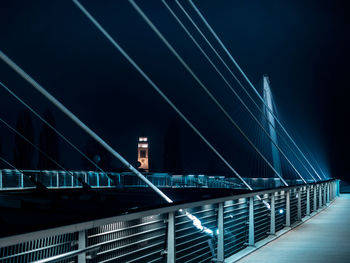 Low angle view of illuminated bridge against sky at night