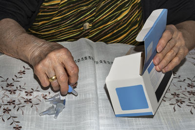 Midsection of man holding paper while sitting on table