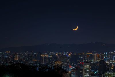 Illuminated city against sky at night