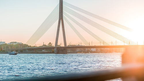 View of suspension bridge over river against sky