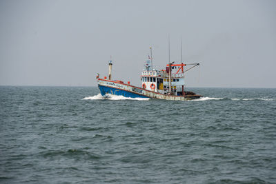 Ship sailing in sea against clear sky