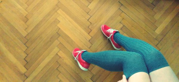 Low section of woman standing on hardwood floor