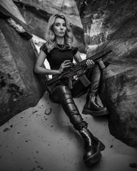 Portrait of young woman sitting on rock