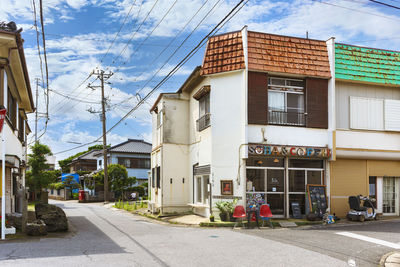 Street by buildings in city against sky