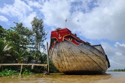 Ship moored on beach against sky