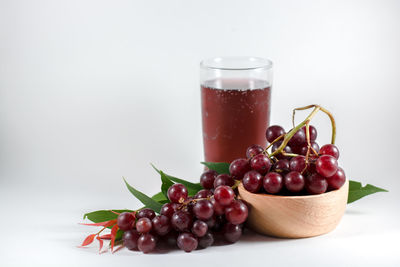 Close-up of fruits in glass on table against white background