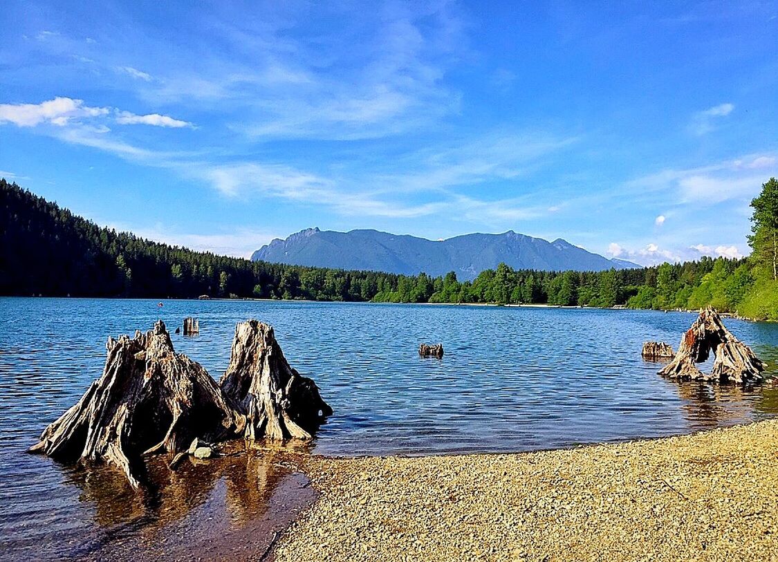 water, mountain, sky, tranquil scene, tranquility, scenics, lake, beauty in nature, blue, nature, nautical vessel, mountain range, cloud - sky, cloud, idyllic, lakeshore, transportation, non-urban scene, rock - object, tree