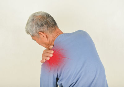 Side view of man standing against white background