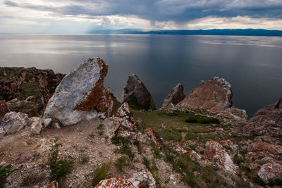 Scenic view of rocks in sea against sky