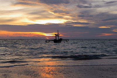 Silhouette boat in sea against sky during sunset