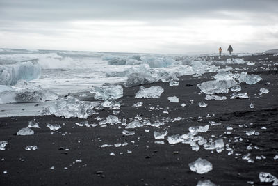 Ice blocks on diamond  beach, sea waves, black sand. jokulsarlon. atlantic ocean coast, iceland