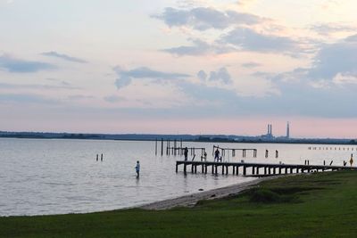 Pier over sea against sky during sunset