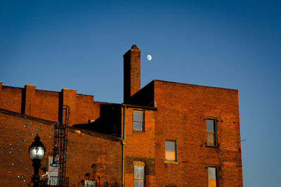 Low angle view of buildings against clear blue sky