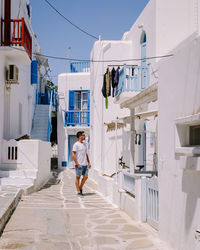 Rear view of woman walking amidst buildings in city