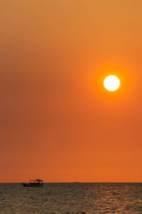 Scenic view of sea against orange sky