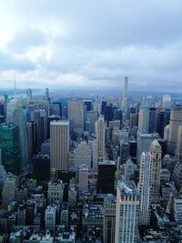 Aerial view of cityscape against cloudy sky