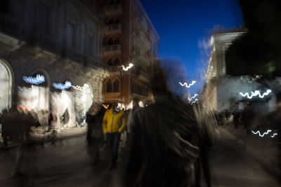 People in illuminated city at night