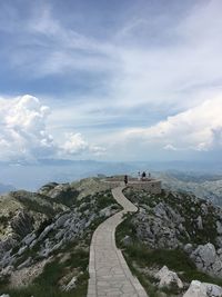 High angle view of people standing on mountain against cloudy sky